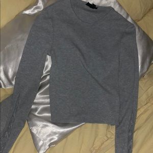 Gray long sleeve top with crosses on the arms.